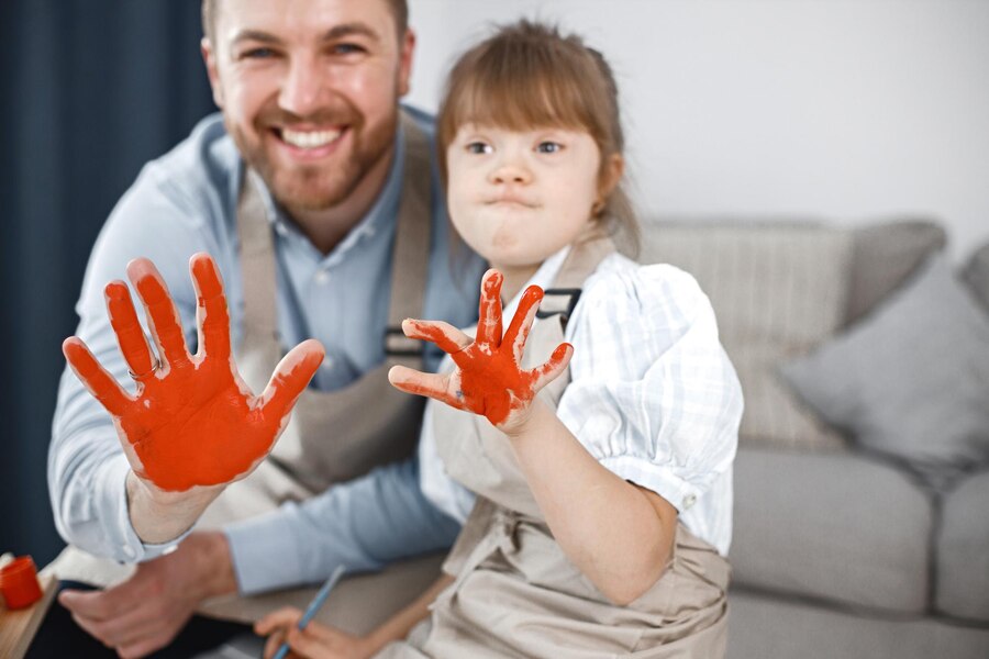 girl-with-down-syndrome-her-father-painted-hands-red-colour_1157-52325
